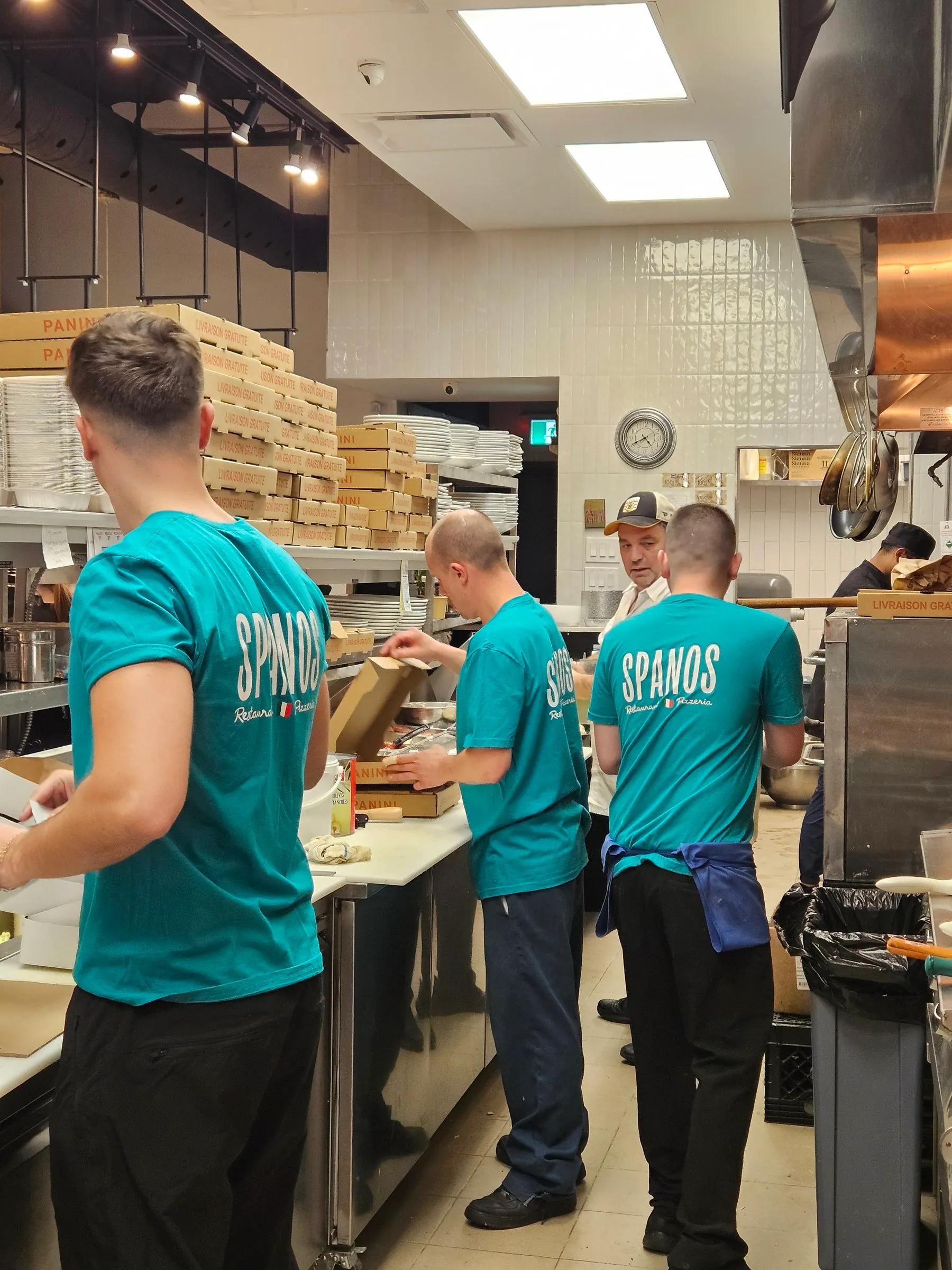 L’équipe en chandails Spanos prépare les commandes en cuisine