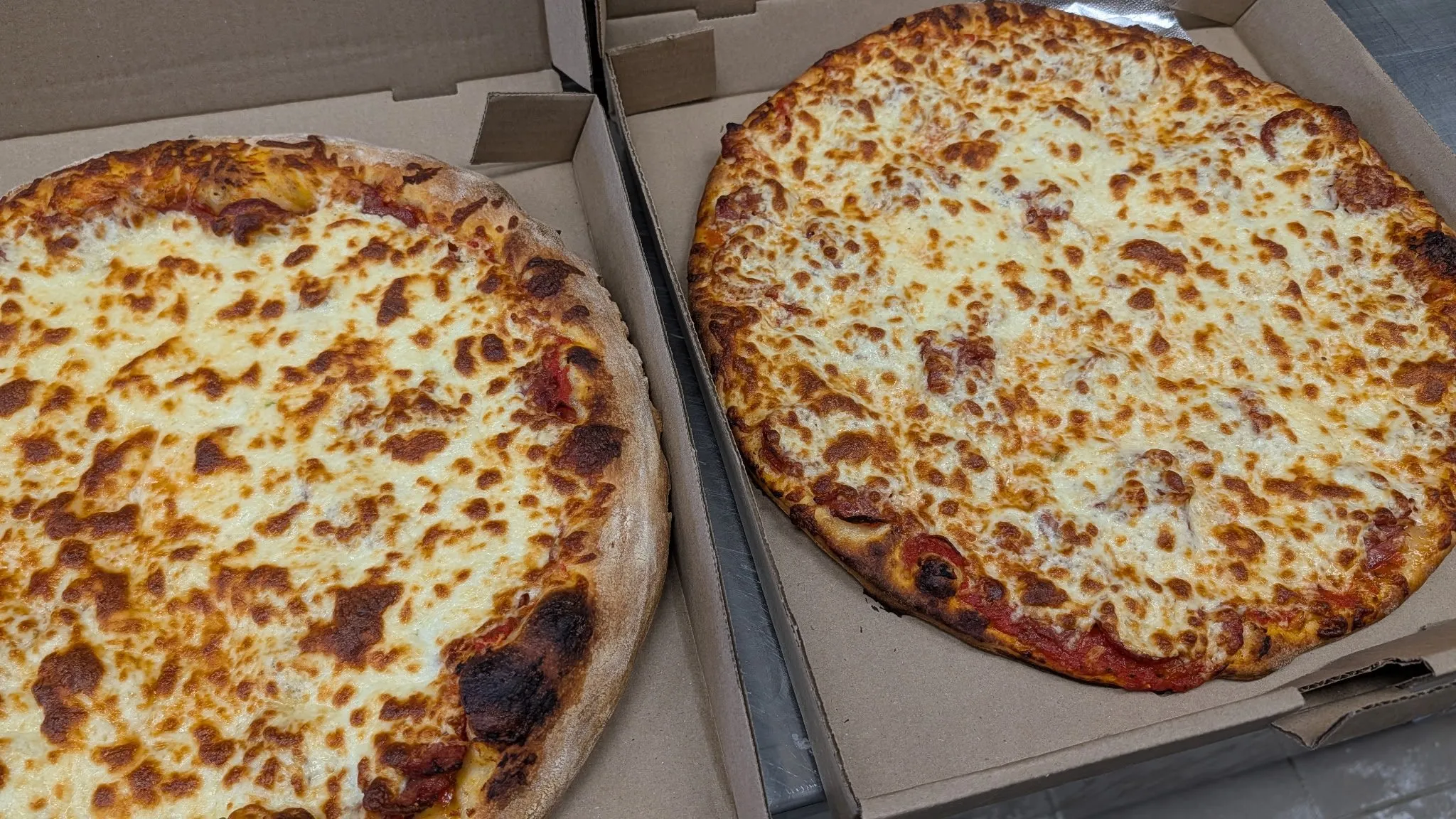 Deux grandes pizzas au fromage dans leurs boîtes pour emporter