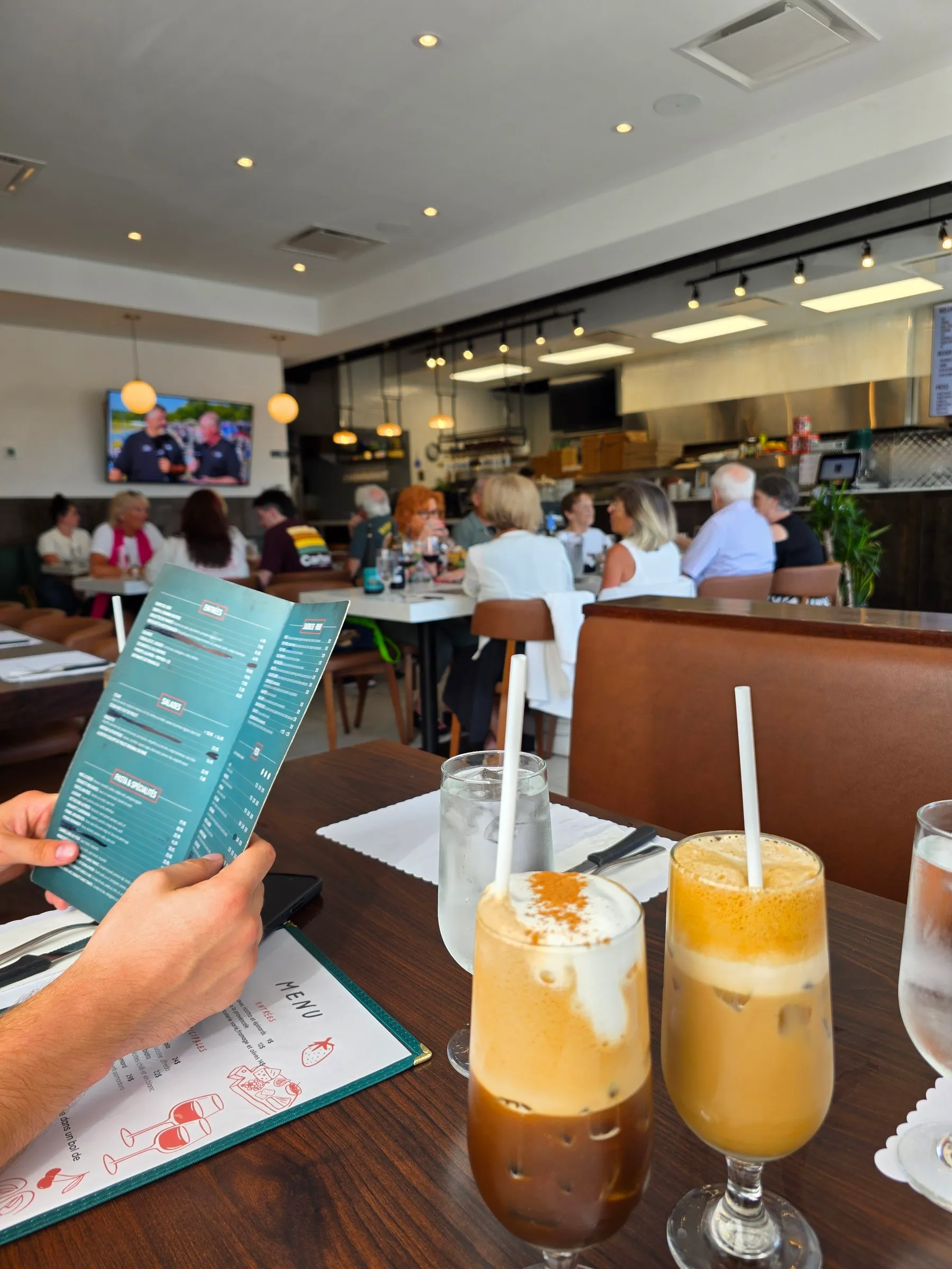 Deux cafés glacés et le menu Spanos à une table de la salle à manger