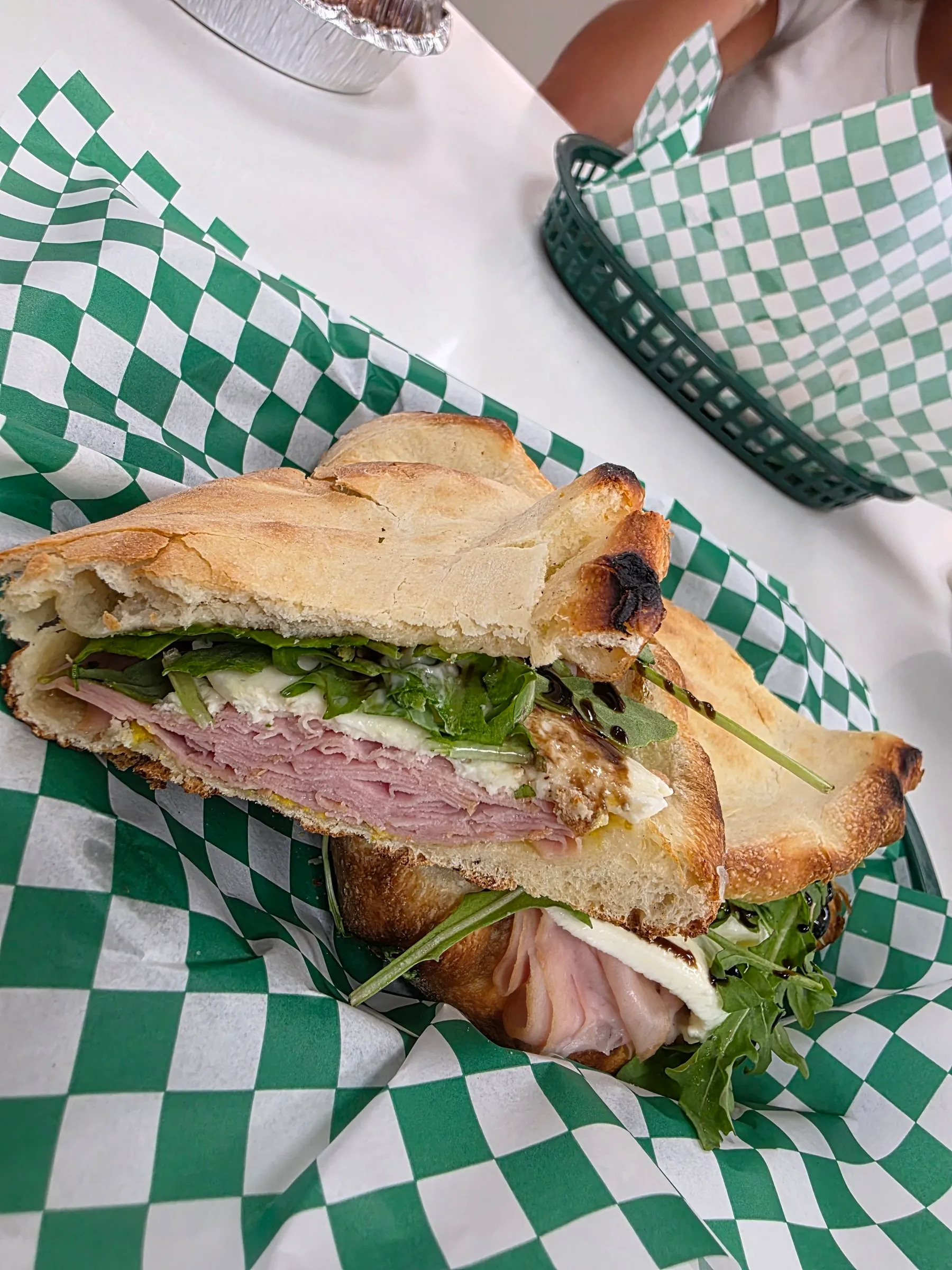 Sous-marin au jambon, au fromage et à la roquette, coupé en deux